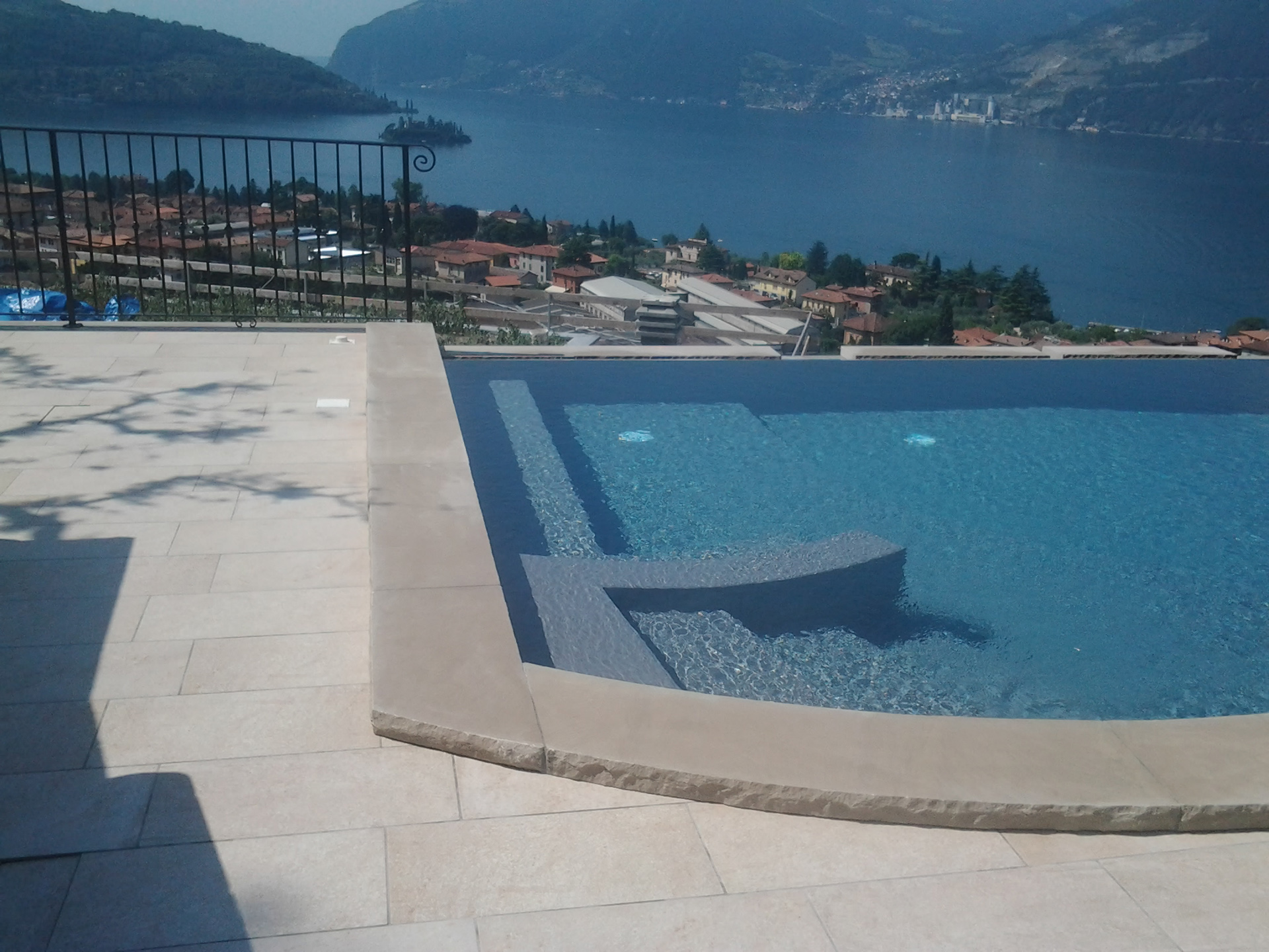 Bordo piscina in ivory con costa a spacco Bordo piscina eseguito in pietra Ivory con finitura spazzolata con trattamento antiscivolo.